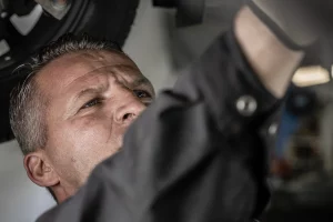 Auto mechanic inspecting and servicing a vehicle